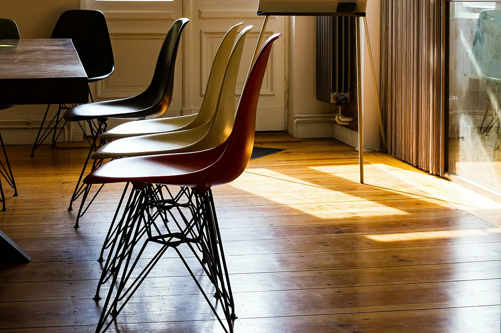 Shell chairs in a row in a sunlit training room, a flip chart stand by the window